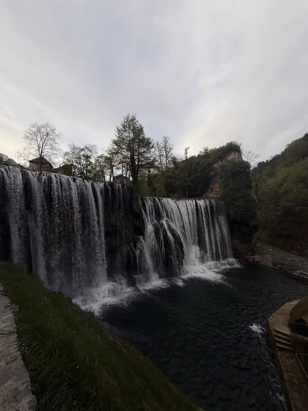 Foto de una cascada ancha entre árboles